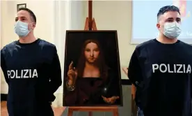  ?? Photograph: Ciro Fusco/EPA ?? Police officers stand next to the recovered Salvator Mundi painting. A 36-year-old flat owner has been arrested on suspicion of receiving stolen goods.