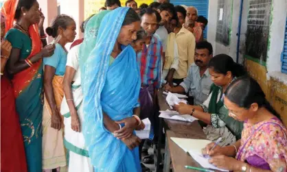  ??  ?? Indian residents waiting to vote queue to be processed by election officials at a polling station in 2014. Photograph: AFP/Getty Images