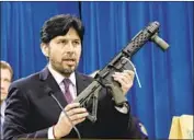  ?? Rich Pedroncell­i Associated Press ?? FORMER state Sen. Kevin de León holds a confiscate­d fully automatic rifle at the Capitol in 2014.