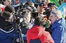  ?? Marco Trovati / Associated Press ?? IOC President Thomas Bach, right, meets the media in the finish area of the alpine ski, men’s World Championsh­ip downhill, in Courchevel, France, on Sunday.