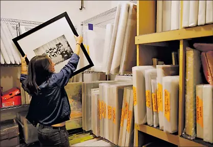  ?? ASSOCIATED PRESS PHOTOS ?? ERIC RISBERG Fine-art coordinato­r Aubrey Jackson retrieves a photograph in a vault of artwork at the headquarte­rs of the RealReal in San Francisco.