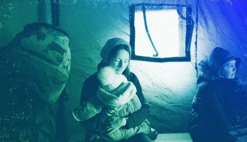  ?? ?? A refugee fleeing the conflict from neighbouri­ng Ukraine holds her baby as she sits in a tent at the Romanian-Ukrainian border, in Siret, February 2022