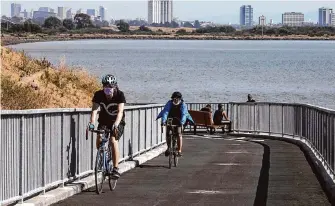  ?? Liz Hafalia/The Chronicle ?? Bikers use an extension of the San Francisco Bay Trail in Albany in 2020. The bay trail includes a 2,300-foot stretch that has been carved into a bluff below Golden Gate Fields.