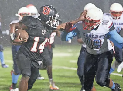  ?? MICHAEL SEARS/MILWAUKEE JOURNAL SENTINEL ?? Milwaukee Bay View’s Isiah Wright pushes his way past Milwaukee Marshall’s Kerryon Taylor on Friday night in the City Conference championsh­ip game. Bay View won, 55-20. Story on 4B.