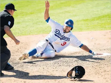  ?? Photograph­s by Kevork Djansezian Getty Images ?? MUCH OF THE DAMAGE had already been done by the time Chris Taylor slid home to give Dodgers a 9-6 lead in the eighth. Taylor scored on the last of four wild pitches by Colorado’s Adam Ottavino that sparked L.A.’s comeback from a 6-4 seventh-inning...