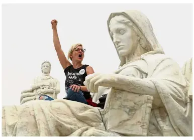  ??  ?? The fight’s not over: Demonstrat­or Jessica CampbellSw­anson standing on the lap of the Contemplat­ion of Justice statue outside the US Supreme Court during a protest against Kavanaugh’s appointmen­t at Capitol Hill in Washington.
