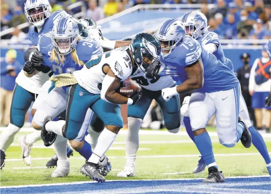  ?? RICK OSENTOSKI/AP ?? Eagles running back Boston Scott rushes for a touchdown during the first half of Sunday’s game against the Lions in Detroit. Scott had a second touchdown in the third quarter.