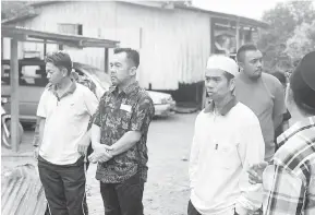  ??  ?? TINJAU: Jamawi bersama rombongan ketika melihat Suasana persekitar­an rumah yang terbakar semasa ziarah tersebut.