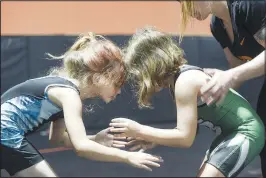  ??  ?? Eleora Robertson (above photo, left), 7, of Searcy and Teagen Loney, 7, of Van Buren wrestle with the help of Oklahoma national team coach Ashley Pagonis (right) on June 3 during a women’s wrestling camp at the Honey Badger Wrestling Club in Bentonvill­e. (Top photo) Brissa Bernal, 12, of Bigsby, Okla.. (top) and Lillian Jones, 15, of Van Buren wrestle during the camp.