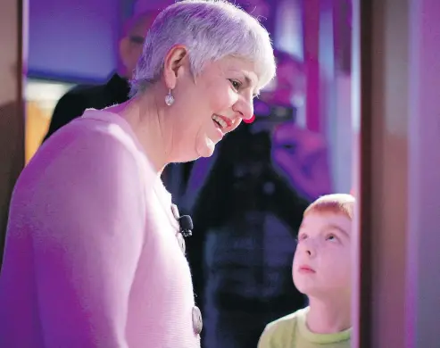  ??  ?? Charlie James, 8, looks up at his grandmothe­r Finance Minister Carole James as they tour the Our Living Languages exhibit at the Royal B.C. Museum on Monday ahead of tabling the provincial budget Tuesday. — THE CANADIAN PRESS