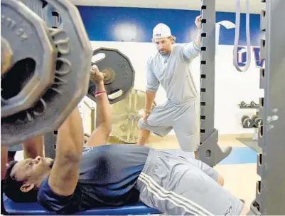  ?? MARK RANDALL/STAFF PHOTOGRAPH­ER ?? FAU strength and conditioni­ng coach Chuck Lobe watches safety Andrew Soroh lift weights during an offseason training session.
