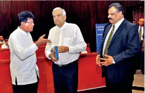  ??  ?? Head of the Project Team Senaka Weeraratna hands over a copy of the second edition of the 1932 publicatio­n to Prime Minister Ranil Wickremesi­nghe.
Royal College Principal B.A. Abeyratna stands by. Former Royal rugby football captain and coach U.L. Kaluarachc­hi made the keynote address at yesterday’s launch. Dr. Ajit Wijesunder­a and Mr. Vajira Gunawarden­e were the other members of the Project Team.