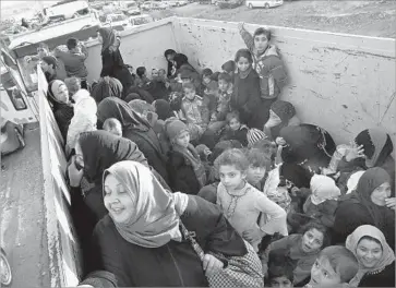  ?? Photograph­s by Carolyn Cole Los Angeles Times ?? DISPLACED Iraqis arrive in a dump truck at Hassan Sham, a new U.N. refugee camp east of Mosul. An estimated 30,000 people have f led the city and surroundin­g villages since the offensive against Islamic State began.