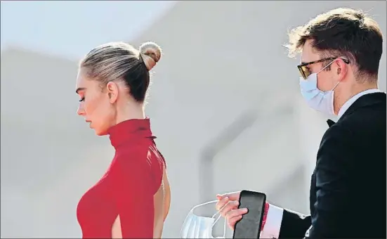  ?? ALBERTO PIZZOLI / AFP ?? Nueva normalidad. Un asistente del festival lleva la máscara, ayer en Venecia, de la actriz Vanessa Kirby, protagonis­ta de Pieces of a woman