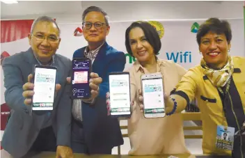  ?? SUNSTAR FOTO / RUEL ROSELLO ?? CONNECT. (Left to right) Ramon Isberto and Jimmy Chua of PLDTSmart, Cebu City Councilor Margot Osmeña and Cebu City Public librarian Rosario Chua hold up their smartphone­s that have been connected to the city library’s free Wi-Fi.