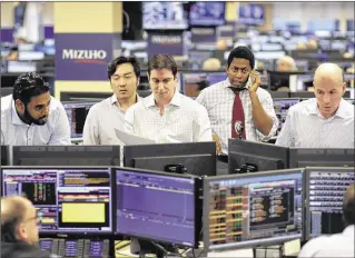  ?? MARK LENNIHAN / AP ?? Traders work on the Mizuho Americas trading floor in New York last week. A number of large trading firms and individual investors have started to trade stocks based on President-elect Donald Trump’s tweets. Some firms actually have set up computer...