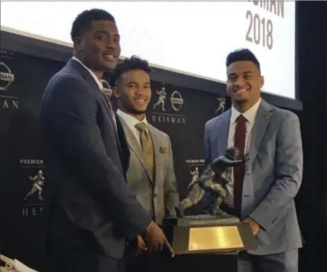  ?? RALPH RUSSO - THE ASSOCIATED PRESS ?? Heisman Trophy finalists, from left, Dwayne Haskins of Ohio State, Kyler Murray of Oklahoma and Alabama’s Tua Tagovailoa pose with the Trophy on Dec. 7 at the New York Stock Exchange.