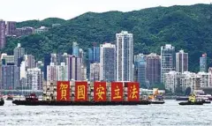  ?? CALVIN NG / CHINA DAILY ?? A barge, displaying five Chinese characters saying “Congratula­tions on passing the national security law”, sails at Victoria Harbor on Wednesday.