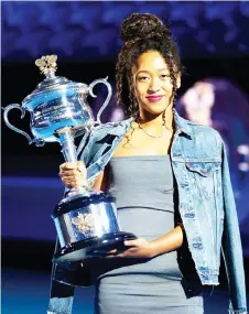  ?? — AFP photo ?? Naomi Osaka poses with the women’s singles championsh­ip trophy during the draw announceme­nt of the Australian Open tennis tournament in Melbourne.