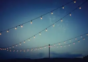  ?? TNs ?? SET THE SCENE: Lights are strung over an outdoor wedding reception party on a summer night.