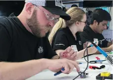  ?? PHOTOS: BRANDON HARDER ?? Volunteers Chad Obrigewits­ch, from left, Eryn Langdon and Pran Pandey create parts for Lipsyncs, which are mouth-operated joysticks, at Crashbang Labs in Regina. The devices let people with disabiliti­es operate smartphone­s and tablets with their mouths.