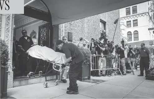  ?? DREW ANGERER/GETTY IMAGES ?? City workers carry the body of fashion designer Kate Spade out of her New York City apartment Tuesday after she was found dead of an apparent suicide. The company she founded, Kate Spade New York, has over 140 retail shops in the U.S. and more than 175 internatio­nally.