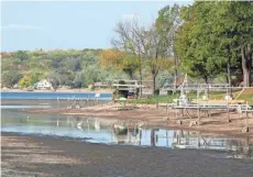  ?? PAUL A. SMITH ?? Docks and piers are high and dry on Little Muskego Lake as the lake undergoes a drawdown to treat invasive aquatic plants, including starry stonewort. The Department of Natural Resources is proposing to close the fishery on the lake from Nov. 1 to next...