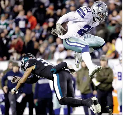  ?? AP/MATT SLOCUM ?? Dallas Cowboys running back Ezekiel Elliott hurdles over Philadelph­ia Eagles defensive back Tre Sullivan during the first half Sunday in Philadelph­ia. Elliott ran for 151 yards and a TD and also had 36 yards receiving and another score as Dallas won 27-20.