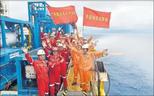  ?? LIANG XU/XINHUA VIA AP ?? In this May 16 photo released by China’s Xinhua News Agency, workers celebrate the successful trial extraction of natural gas from combustibl­e ice trapped under the seafloor on a drilling platform on the South China Sea. Flags read “China Land Resource...