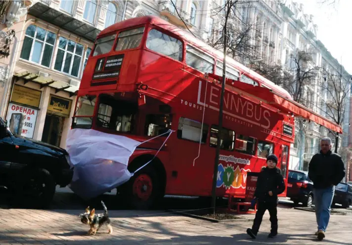  ??  ?? A man and a boy walk past a double-decker bus that is used as a cafe, symbolical­ly wearing a face mask, in Kyiv, Ukraine, yesterday. Ukraine has so far reported more then ten confirmed cases of the new virus and two deaths. Ukrainian government closed the country's border last week, shut down schools, banned public events, suspended public transporta­tion and imposed fines for violating quarantine protocols. For most people, the new Coronaviru­s causes only mild or moderate symptoms. For some, it can cause more severe illness, especially in older adults and people with existing health problems. Photo: AP