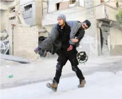  ??  ?? ALEPPO: A Syrian civil defense volunteer, known as the White Helmets, carries an injured man yesterday following an air strike on the rebel-held neighborho­od of Bab Al-Nayrab. — AFP