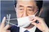  ?? PHOTO: REUTERS ?? Ready to talk . . . Japan's Prime Minister Shinzo Abe takes off his face mask as he arrives to speak to the media in Tokyo yesterday.