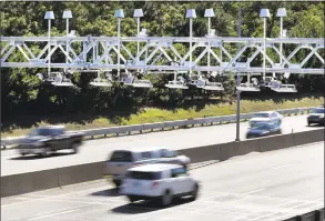  ?? Elise Amendola / Associated Press file photo ?? In this 2016 photo, cars pass under toll-sensor gantries hanging over the Massachuse­tts Turnpike in Newton.