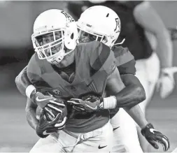  ?? KELLY PRESNELL / ARIZONA DAILY STAR ?? Receiver Cedric Peterson gets wrapped up by Tony Wallace during Arizona's spring game in Tucson on April 14, 2018.