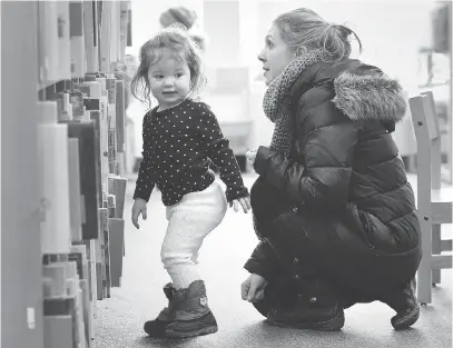  ?? DAN JANISSE ?? Crystal Vaillancou­rt and her daughter Norah, 2, search for a book at the Tecumseh branch of the Essex County Library. Windsor letter writer Grace Kavanaugh says a library is an amazing place for learning, discoverin­g and researchin­g.