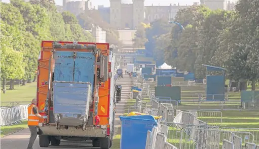  ?? ANDREWMATT­HEWS/ PAVIAAP ?? A bin lorry makes its way down the LongWalk inWindsor, England, during clean- up Sunday after the royal wedding.