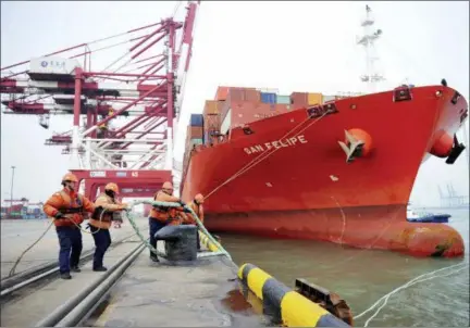  ?? CHINATOPIX VIA AP ?? Workers tie down ropes from a container ship at a port in Qingdao in eastern China’s Shandong province, Thursday. China’s exports in February surged 44.5percent over a year earlier while its politicall­y sensitive trade surplus widened amid mounting...