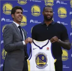  ?? AP PHOTO/BEN MARGOT ?? Golden State Warriors General Manager Bob Myers, left, holds a jersey with DeMarcus Cousins during a media conference Thursday in Oakland. Cousins signed a one-year, $5.3M deal with the defending champion Warriors.