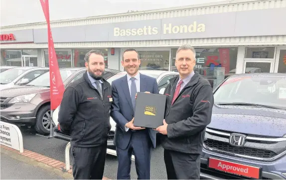  ??  ?? John Boyce receiving his award from Richard Osbourne, the Motability operation manager