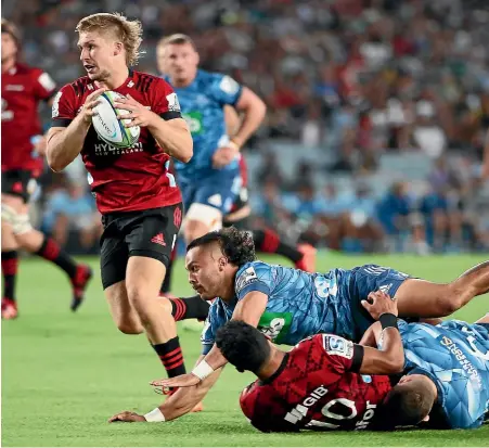  ?? GETTY IMAGES ?? Crusaders second-five Jack Goodhue leaves Blues’ defenders in his wake at Eden Park in February.