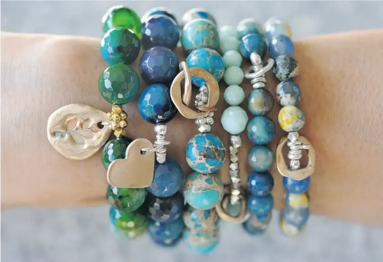 ?? PHOTOS: JOHN LUCAS/ EDMONTON JOURNAL ?? Chunky beaded bracelets are popping up in boutiques around the city. Try mixing and matching various shades of blue bracelets to add a pop of colour to an outfit.