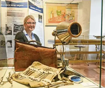  ?? DIRK BERNKOPF (3) ?? Museumslei­terin Katharina Dötterl freut sich, dass sie die alte Arzttasche von Dr. Reinschmid­t aus Gerstungen und ein Original-hebammenbe­steck in der Vitrine ausstellen kann.