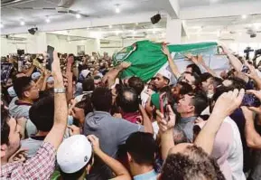  ??  ?? The coffin with Dr Fadi M.R. Albatsh’s remains being brought into Surau Medan Idaman in Setapak, Kuala Lumpur, yesterday.