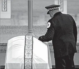  ?? JOHN J. KIM/CHICAGO TRIBUNE ?? Police Superinten­dent Eddie Johnson rests his hand on the casket of Cmdr. Paul Bauer at his funeral Mass in February 2018. Johnson is placing increased emphasis on the well-being of his department’s officers.