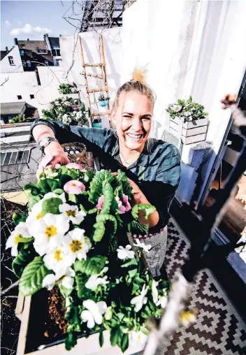  ??  ?? Youtuberin und Floristin Marion Schouten verschöner­t den Problem-Balkon mit obstkisten­artigen Blumenkäst­en, einem Teppich, Töpfen zum Hängen, bunten Kissen und Windlichte­rn.