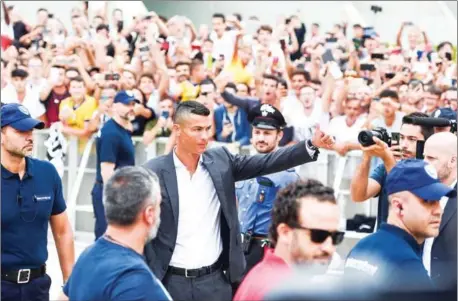  ?? AFP ?? Cristiano Ronaldo waves to fans as he arrives at the medical centre at Juventus Stadium in Turin on Monday.