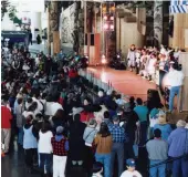  ??  ?? A crowd gathers to watch a fashion show, showcasing over 100 garments at Qaggiq, 1995