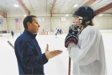  ??  ?? Valor Christian hockey coach George Gwozdecky talks with forward Michael Brown after practice. “He’s like a father, almost, in that you don’t want to do anything wrong, you don’t want to disappoint him,” another player says. Andy Cross, The Denver Post