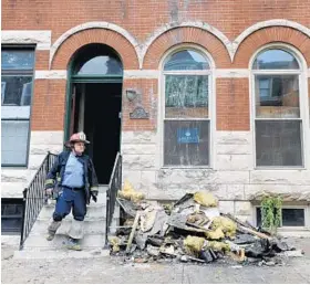  ?? LLOYD FOX/BALTIMORE SUN ?? Firefighte­rs investigat­e a fire at Rep. Elijah Cummings’ rowhouse in West Baltimore. It might have begun in a stove in a tenant’s apartment.