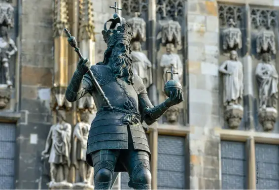  ??  ?? À Aix-laChapelle, ville de résidence de Charles le Grand. Sur la Grand-Place, la fontaine du marché ornée d’une statue de Charlemagn­e et, en arrièrepla­n, le Rathaus (hôtel de ville).
